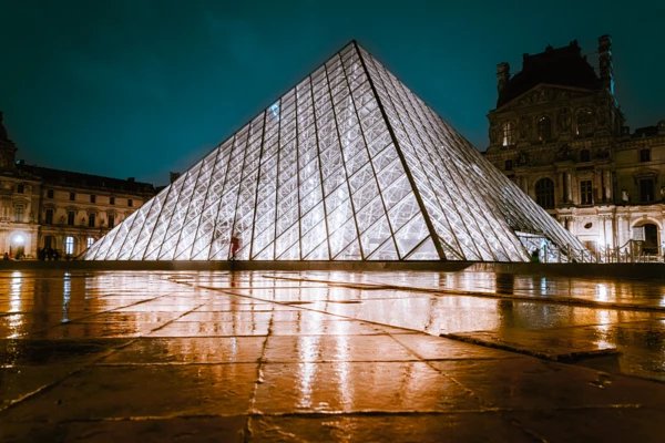 Architekturfotografie des Louvre bei Nacht mit spiegelndem Licht